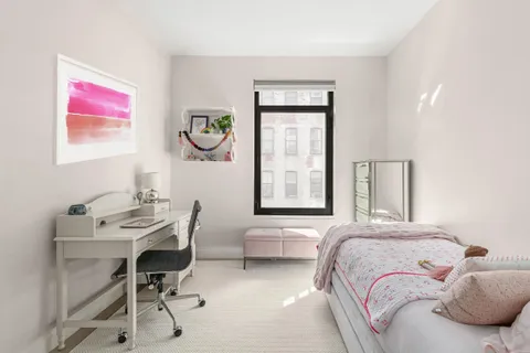 a bedroom with a bed and a table chair