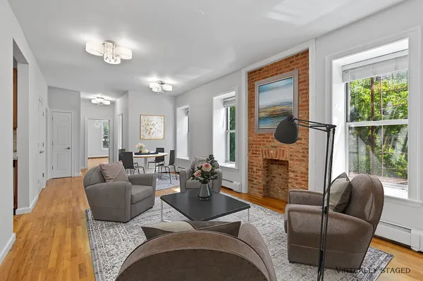 a living room with furniture fireplace and large windows