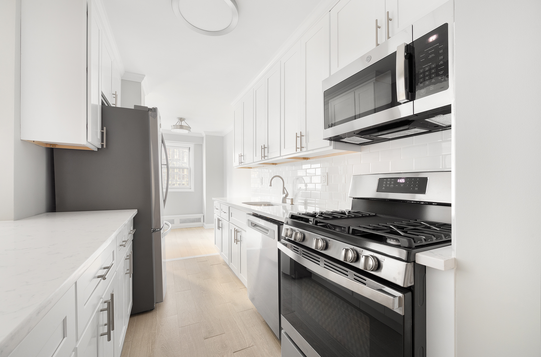 122 Ashland Place, Unit 12L Brooklyn, NY 11201 - Photo 4 of 16 a kitchen with stainless steel appliances granite countertop a stove a microwave and a refrigerator