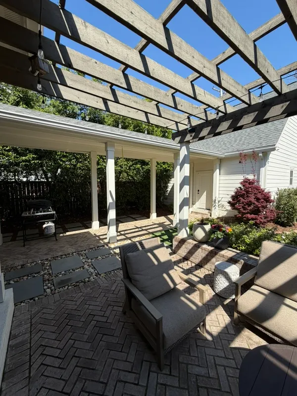 a view of a patio with table and chairs potted plants and large tree