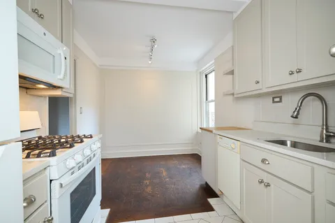 a kitchen with granite countertop a sink stove and cabinets