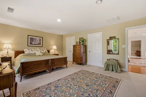 a bed sitting in a spacious bedroom next to a window