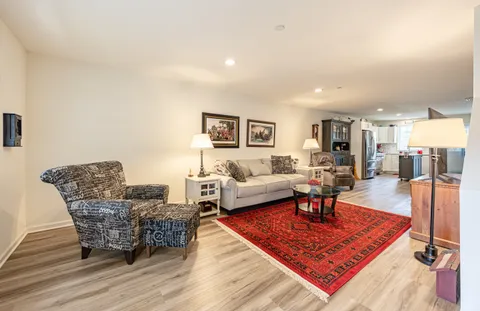 a living room with furniture a rug and a table