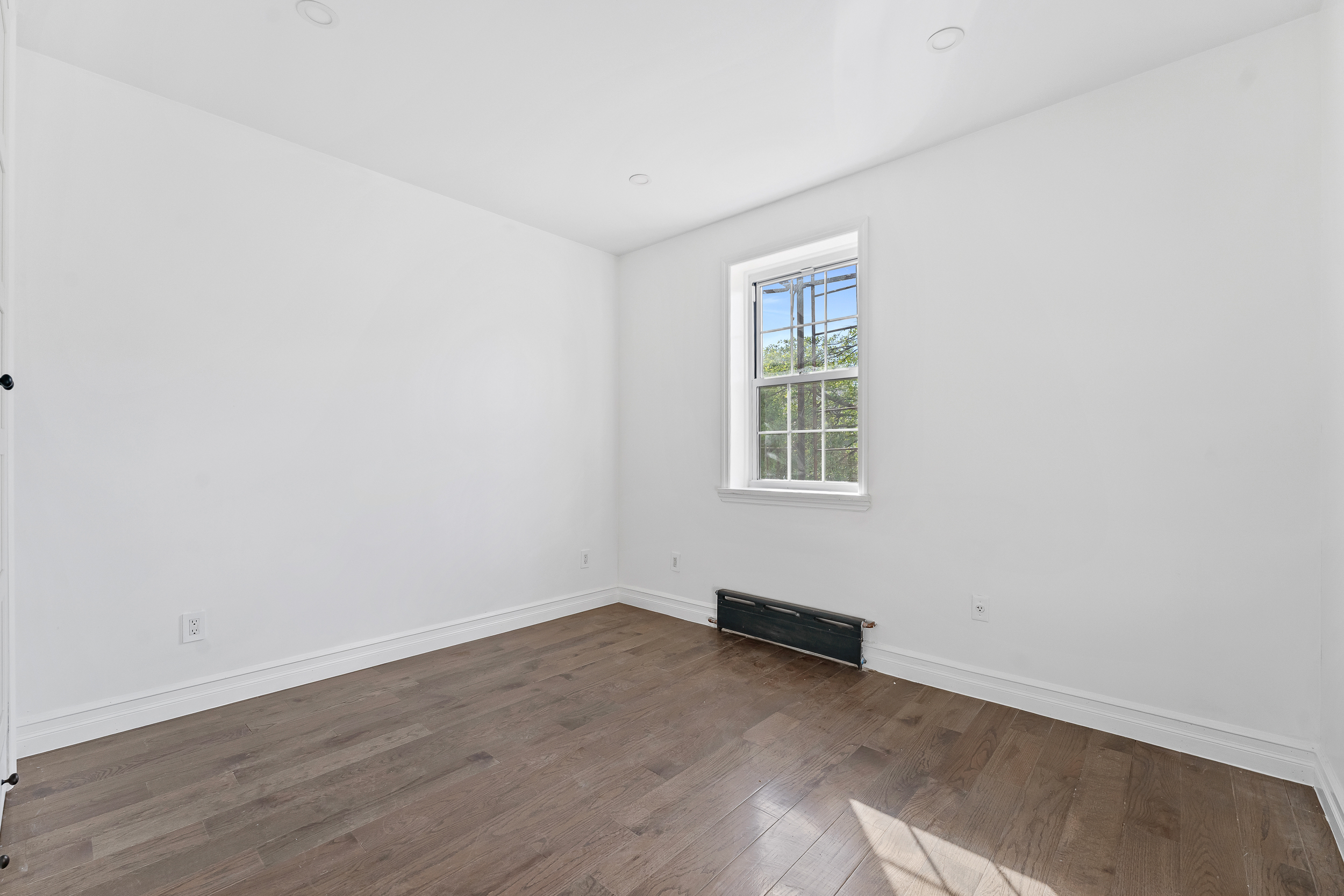 65 Bay 23rd Street, Unit 2 Brooklyn, NY 11214 - Photo 9 of 16 an empty room with wooden floor and windows