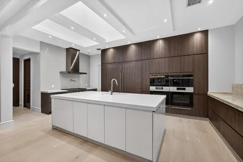 a large kitchen with kitchen island a sink stainless steel appliances and cabinets