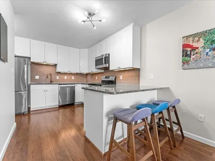 a kitchen with a table chairs refrigerator and microwave
