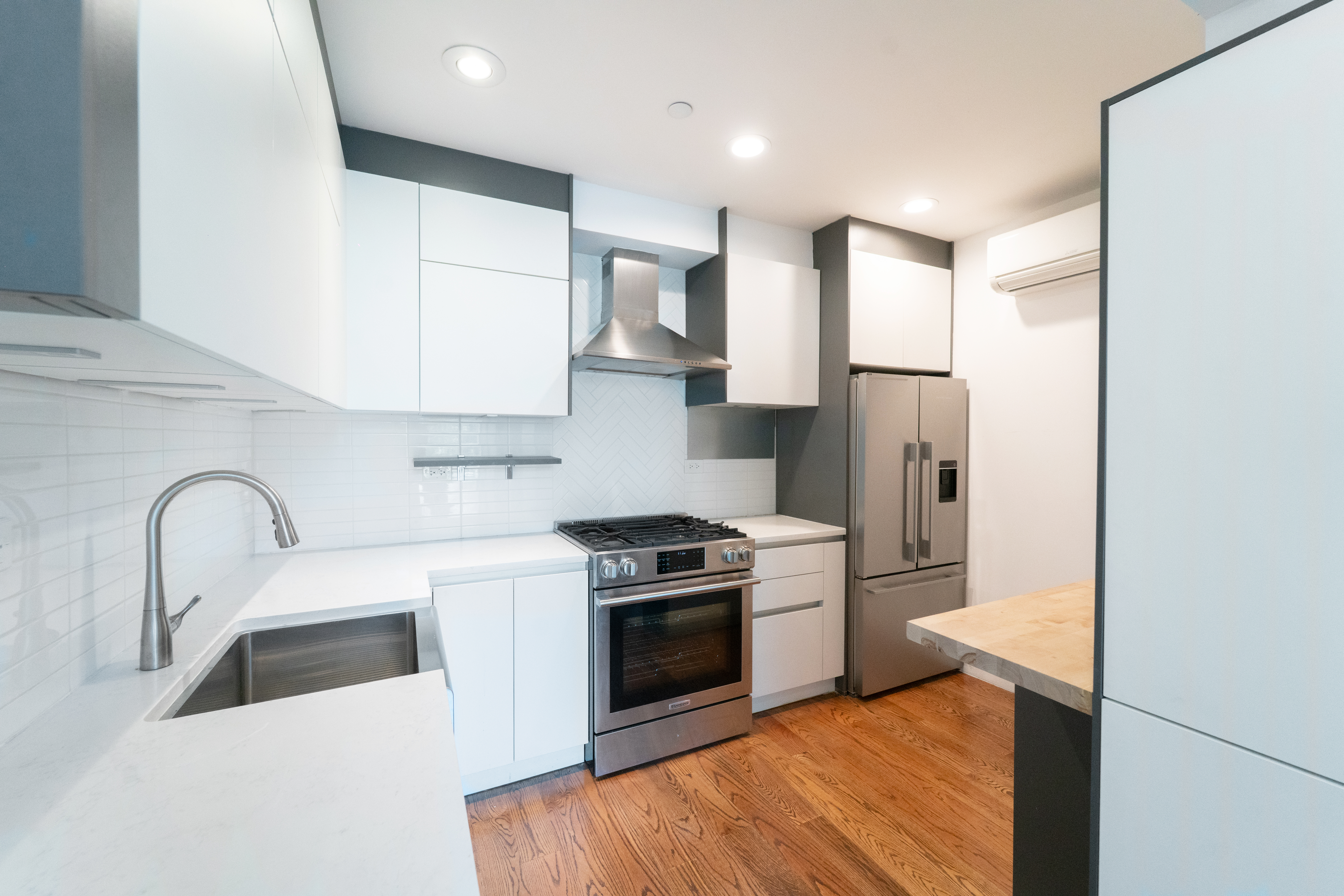 299 Van Buren Street, Unit 4C Brooklyn, NY 11221 - Photo 9 of 16 a kitchen with stainless steel appliances a refrigerator a sink a stove and white cabinets