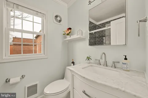 a bathroom with a sink a toilet and a window