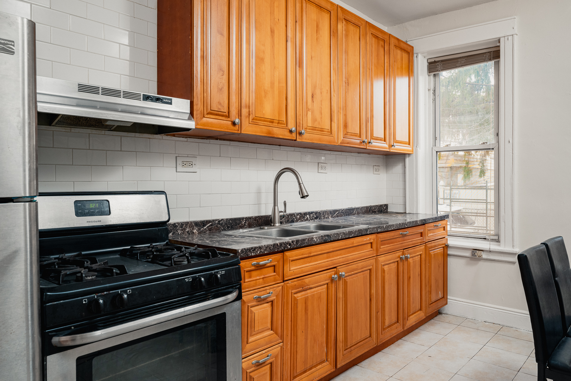 70-03 66th Street, Unit 1L Queens, NY 11385 - Photo 2 of 8 a kitchen with stainless steel appliances granite countertop a stove and a microwave