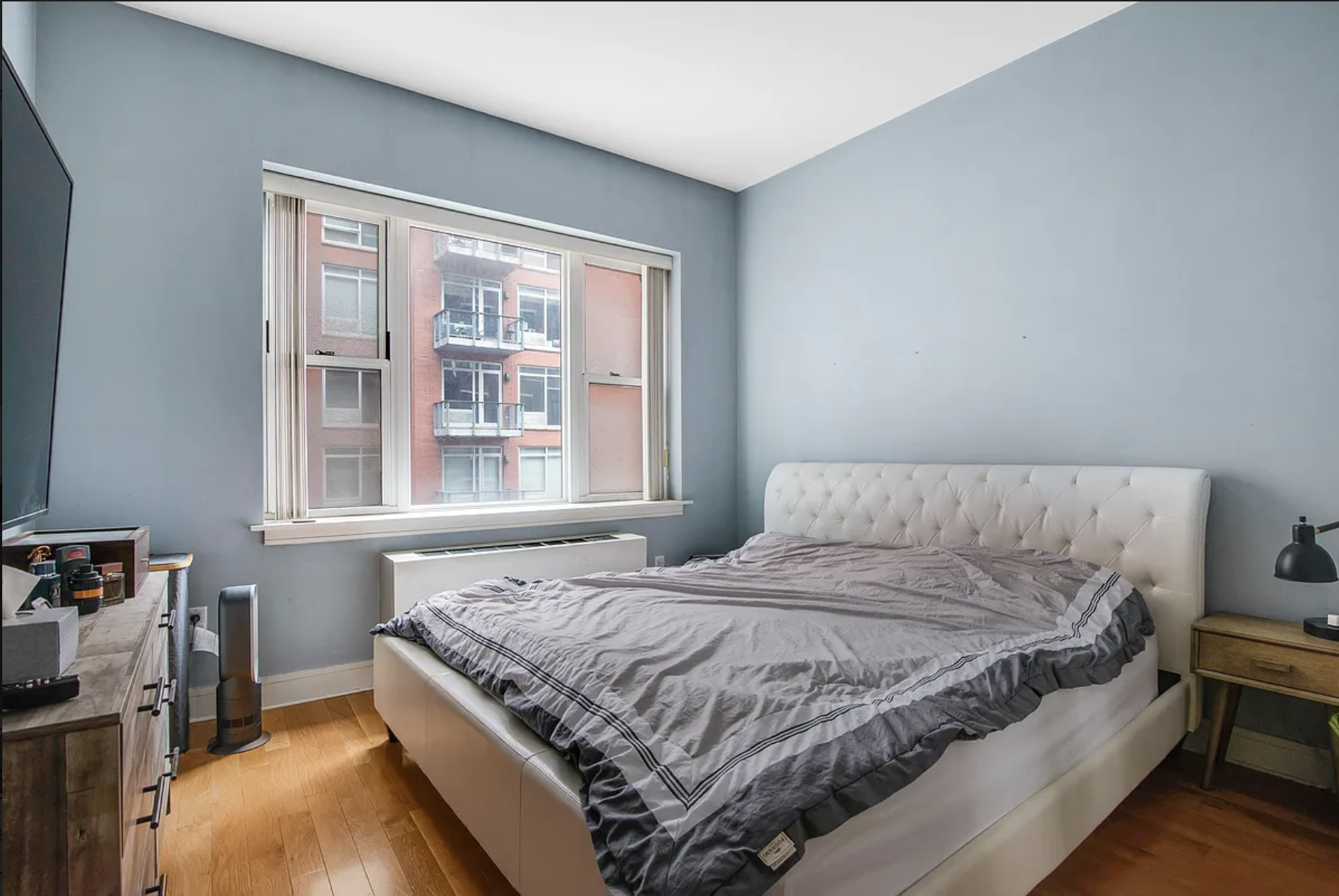 41-26 27th Street, Unit 4B Queens, NY 11101 - Photo 2 of 10 a bed sitting in a bedroom next to a window
