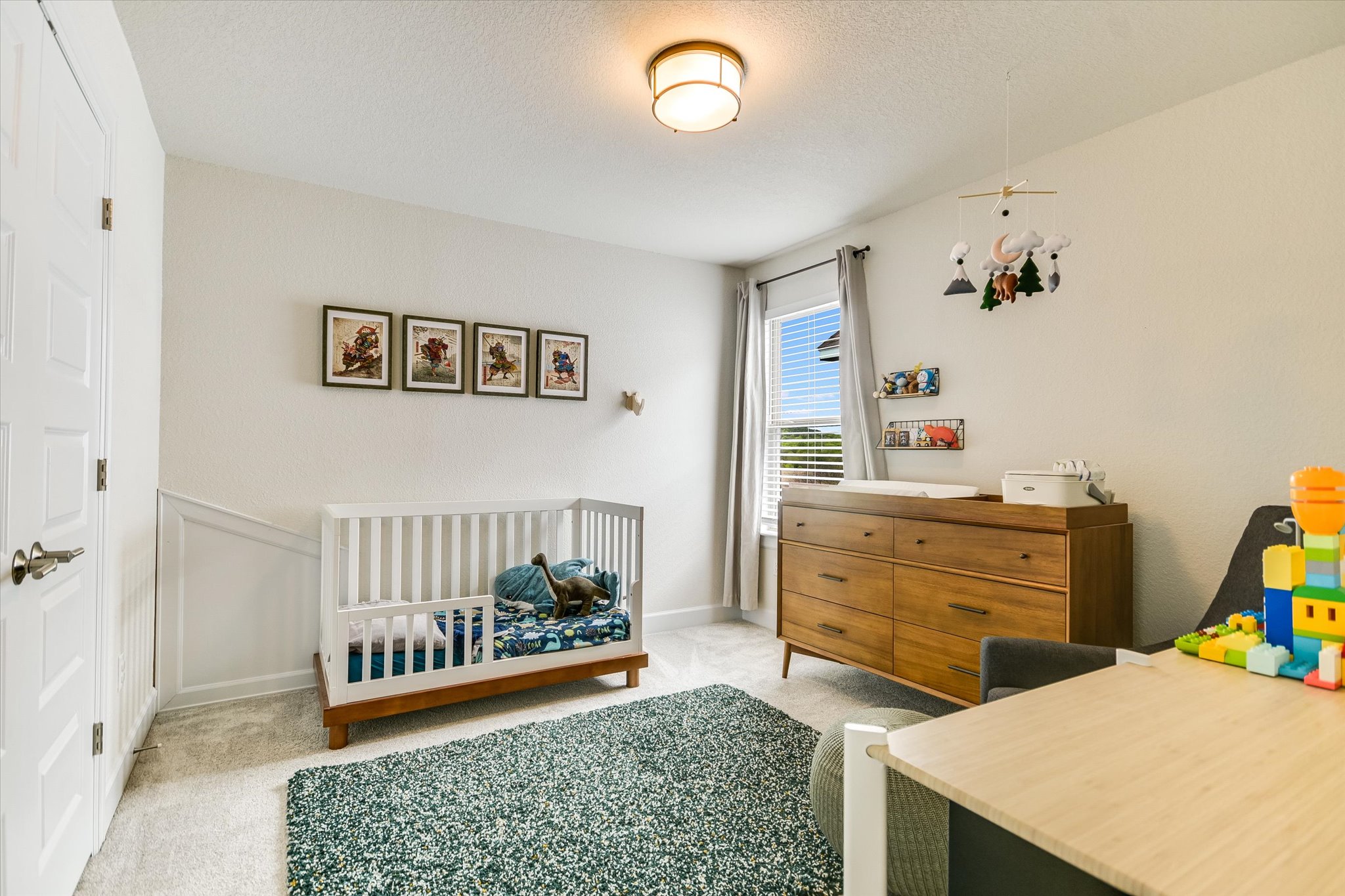 8607 McKamy Drive Austin, TX 78744 - Photo 17 of 28 a view of a bedroom with baby crib and lounge chair
