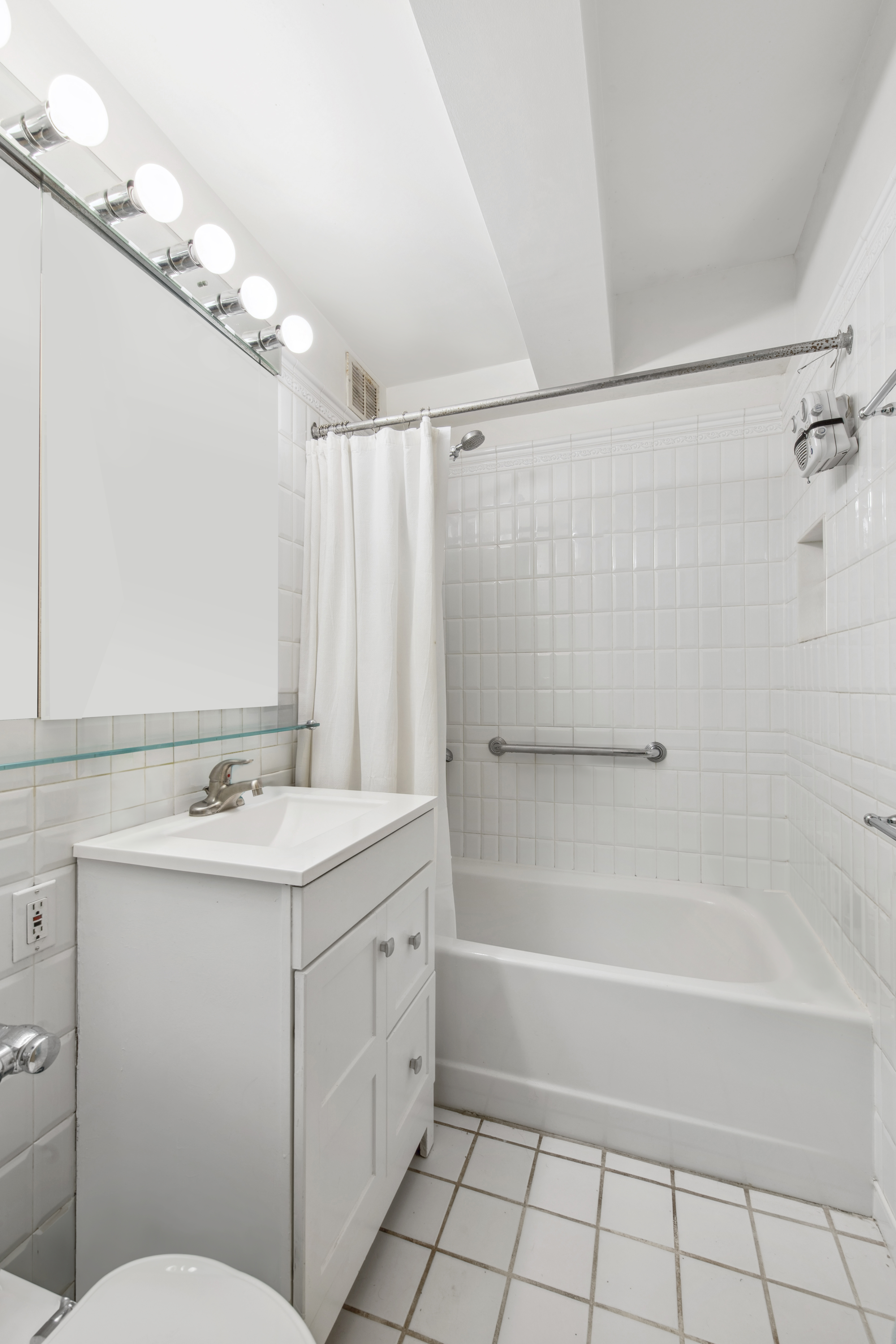 45 West 54th Street, Unit 3CD Manhattan, NY 10019 - Photo 13 of 14 a bathroom with a sink a toilet a mirror a vanity and shower