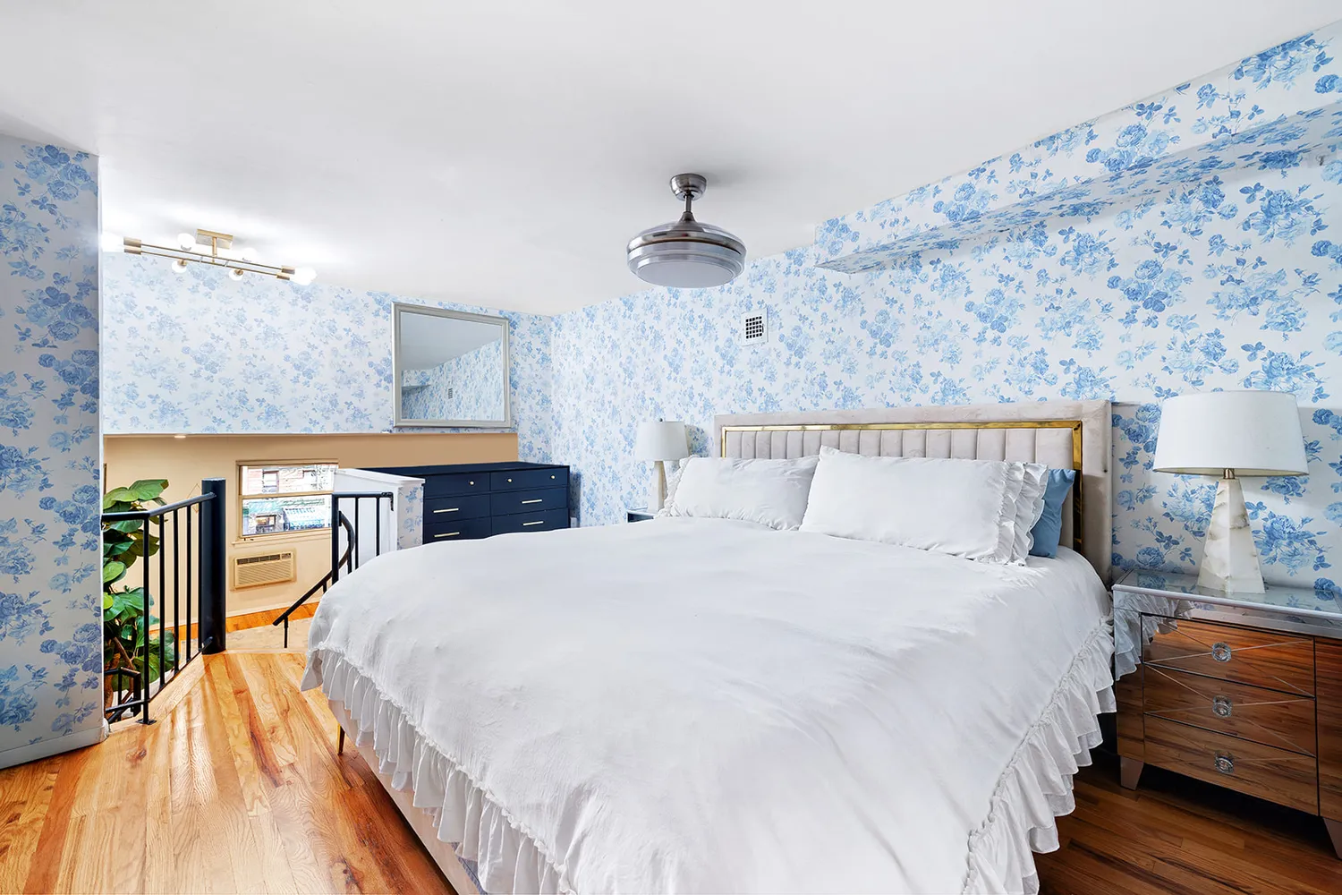 a large bed sitting in a bedroom and chandelier
