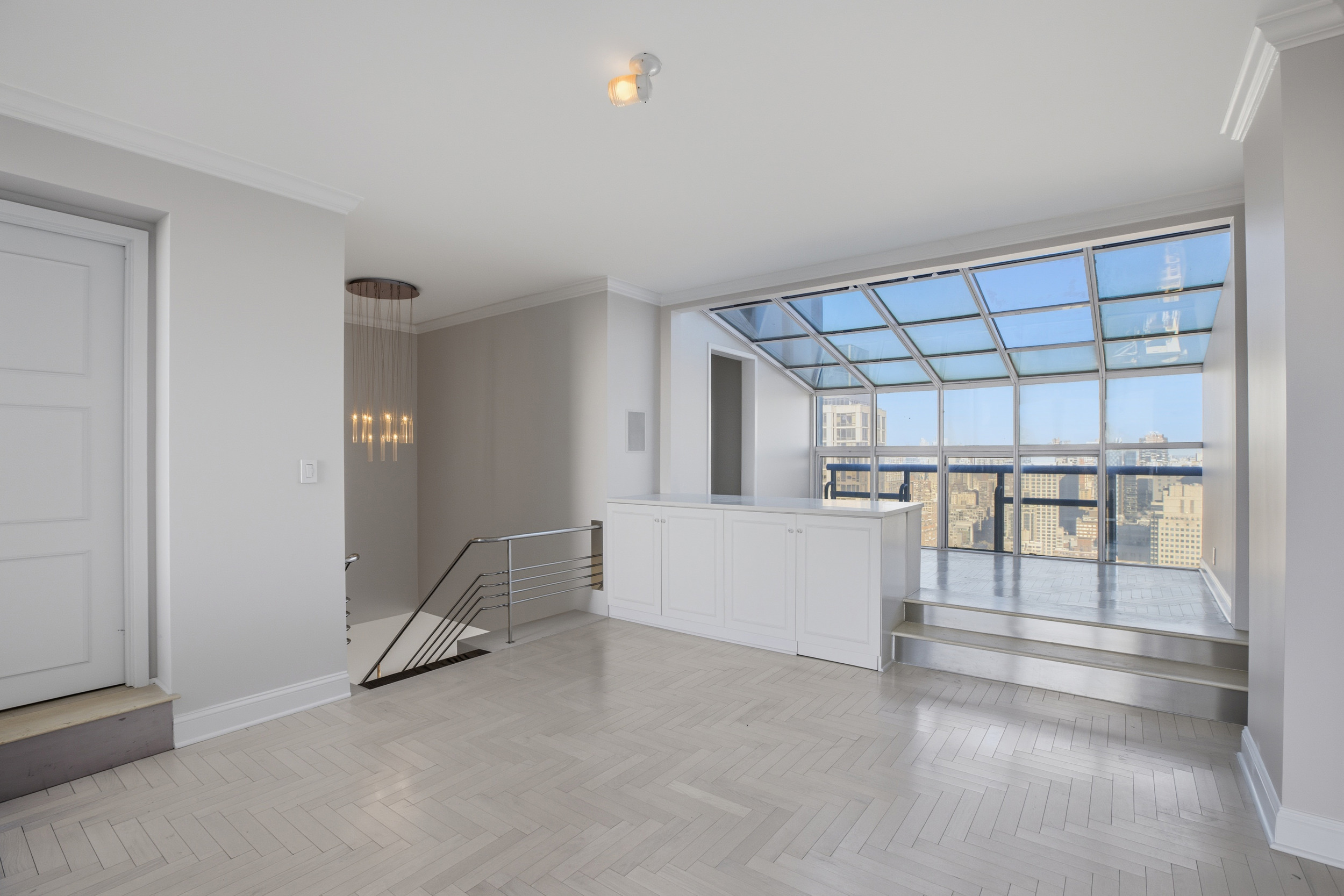 418 East 59th Street, Unit PHA Manhattan, NY 10022 - Photo 13 of 17 an empty room with chandelier