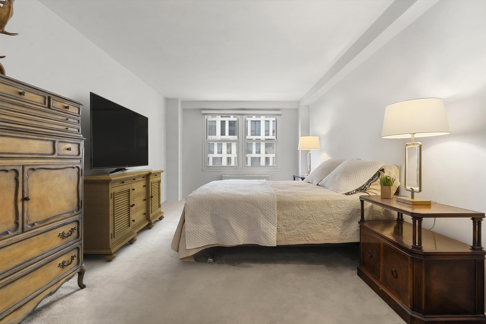 201 East 21st Street, Unit 8E Manhattan, NY 10010 - Photo 4 of 9 a bedroom with a bed and furniture