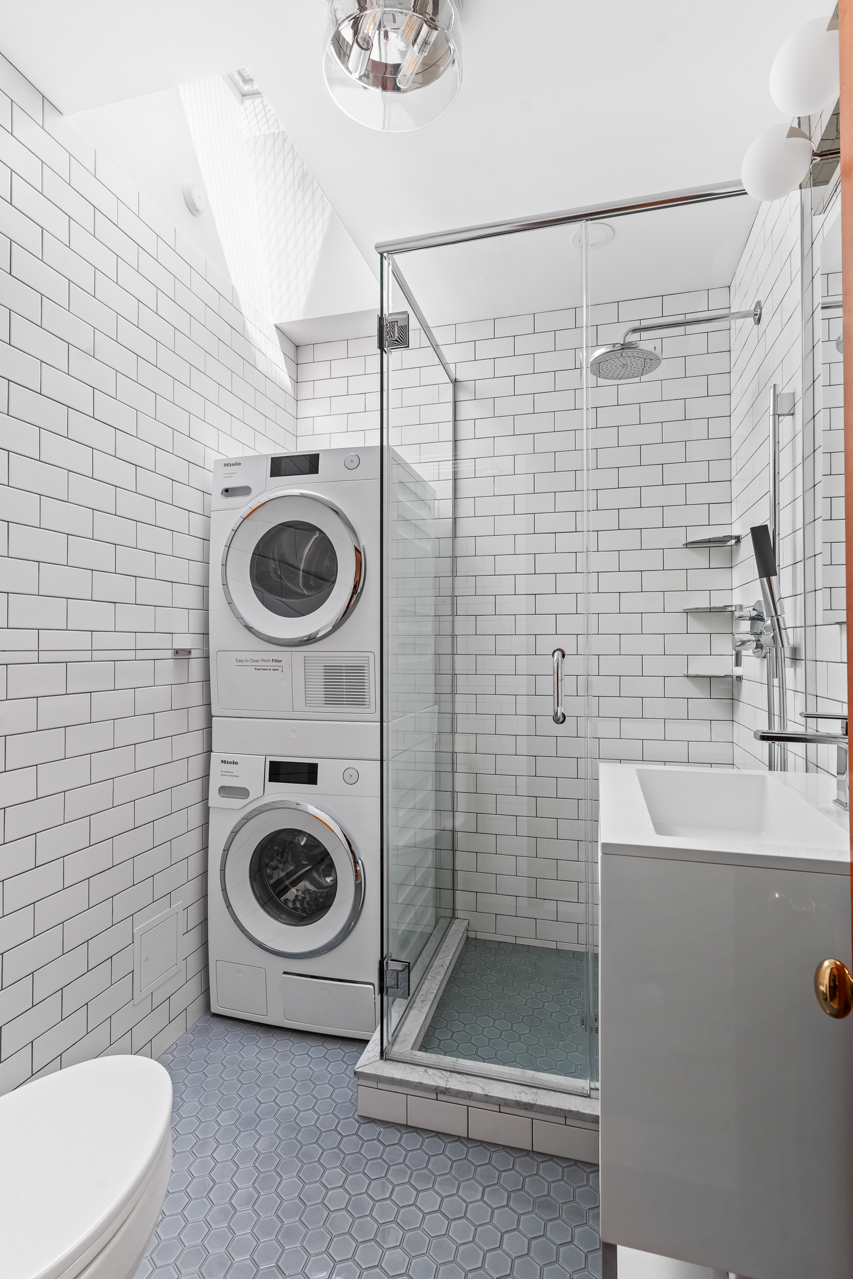 315 Adelphi Street, Unit 3 Brooklyn, NY 11205 - Photo 6 of 10 a bathroom with a sink a washer and dryer