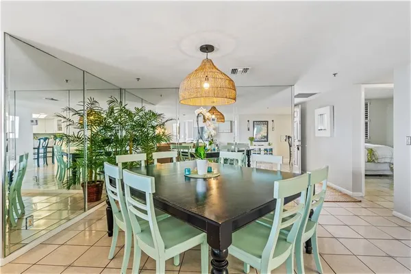 a dining room with chandelier and wooden floor