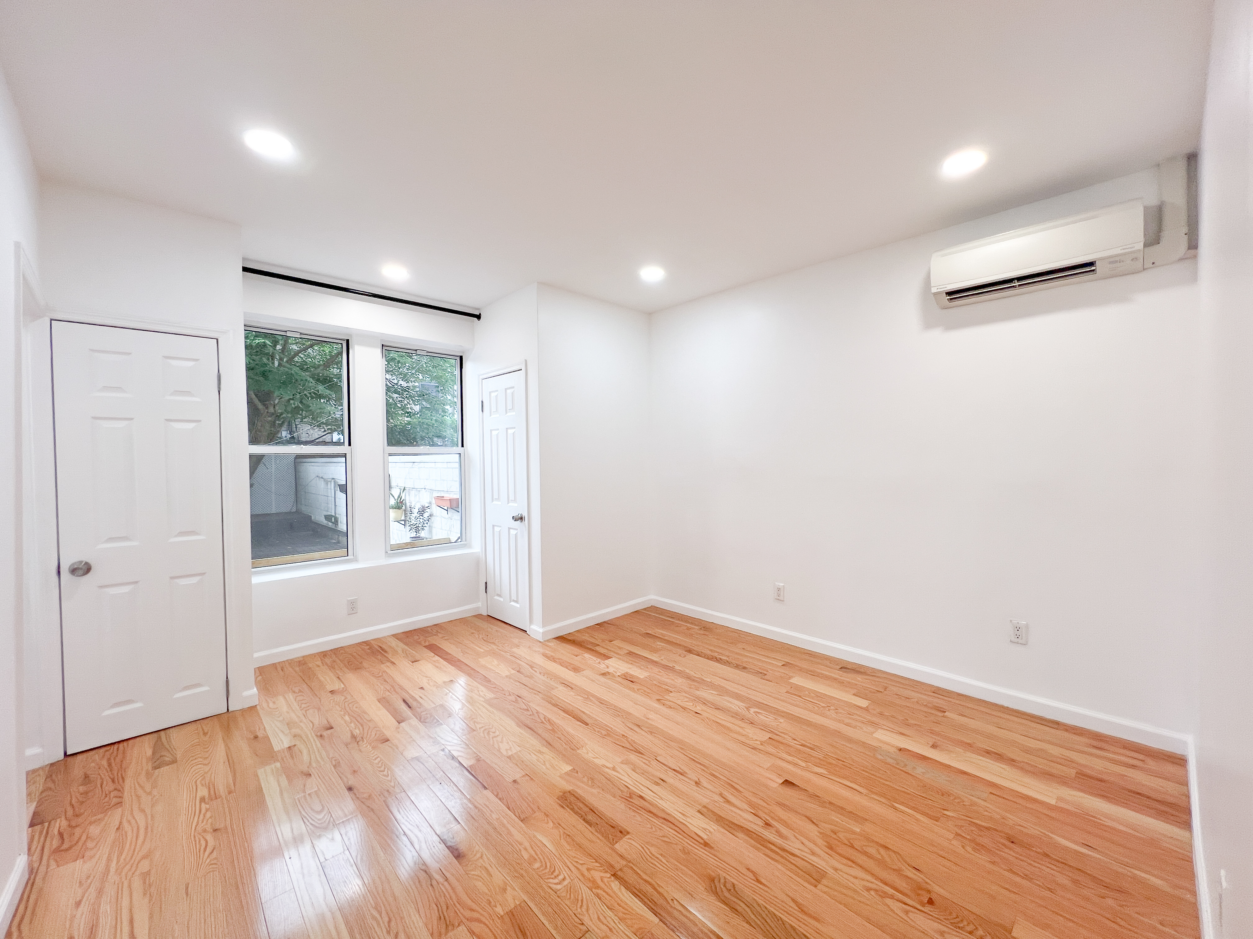 955 Pacific Street, Unit 1 Brooklyn, NY 11238 - Photo 4 of 12 a view of an empty room with wooden floor and a window