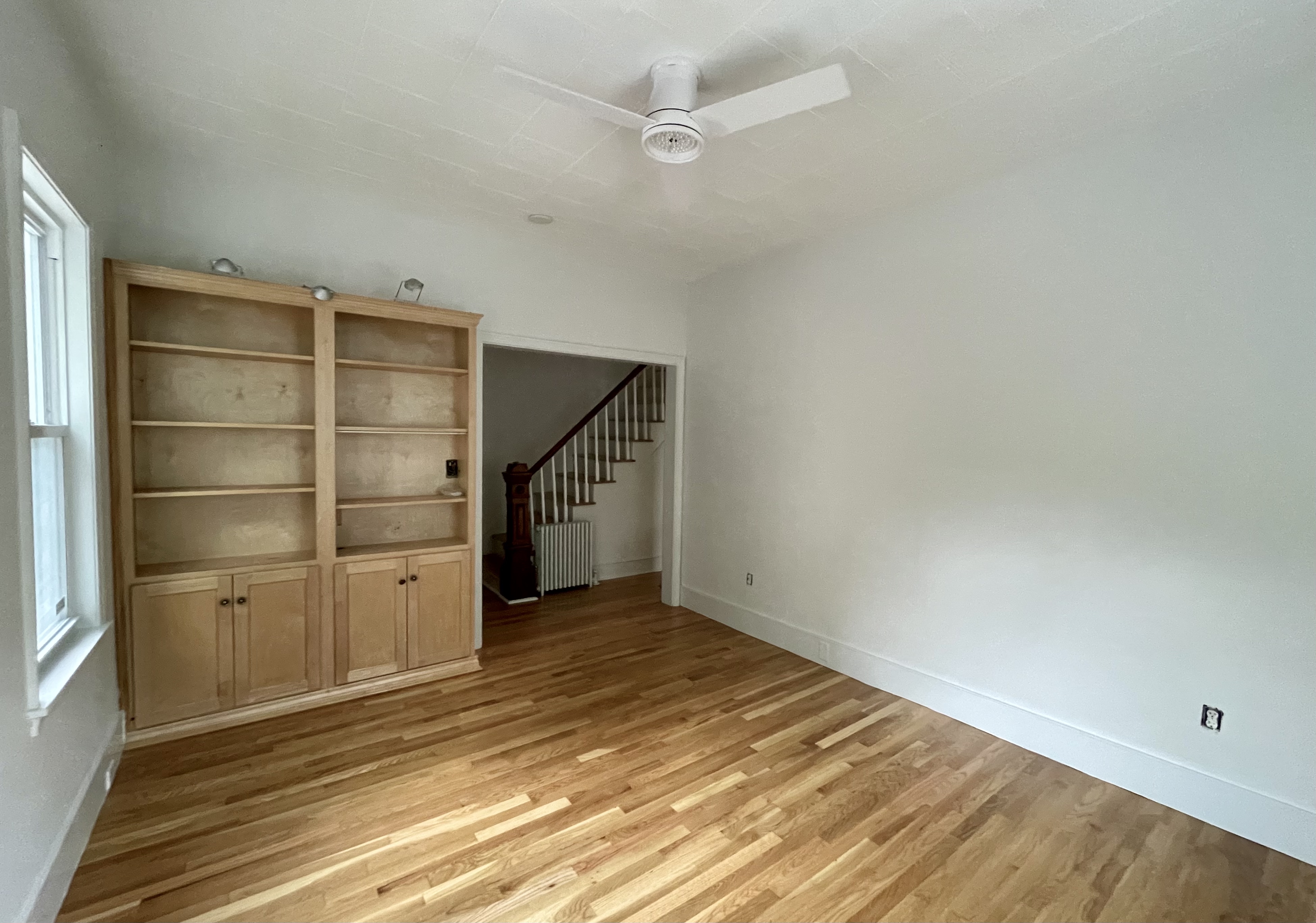 49 8th Street Cambridge, MA 02141 - Photo 3 of 6 an empty room with wooden floor and cabinet