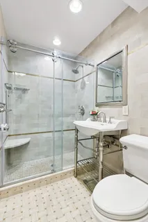 a bathroom with a sink toilet a mirror and shower