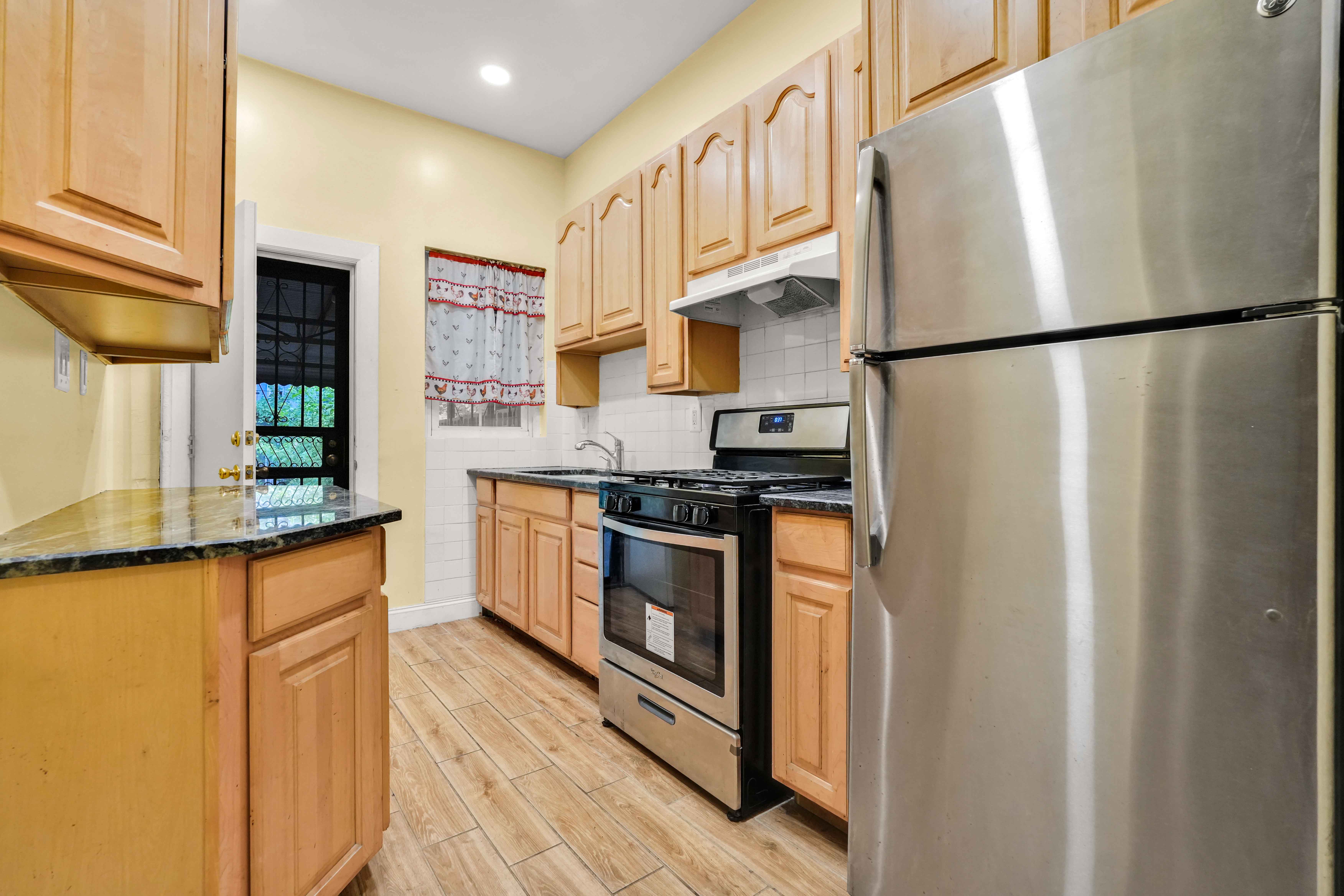 278 Lefferts Avenue Brooklyn, NY 11225 - Photo 33 of 56 a kitchen with stainless steel appliances granite countertop a refrigerator a stove and a sink