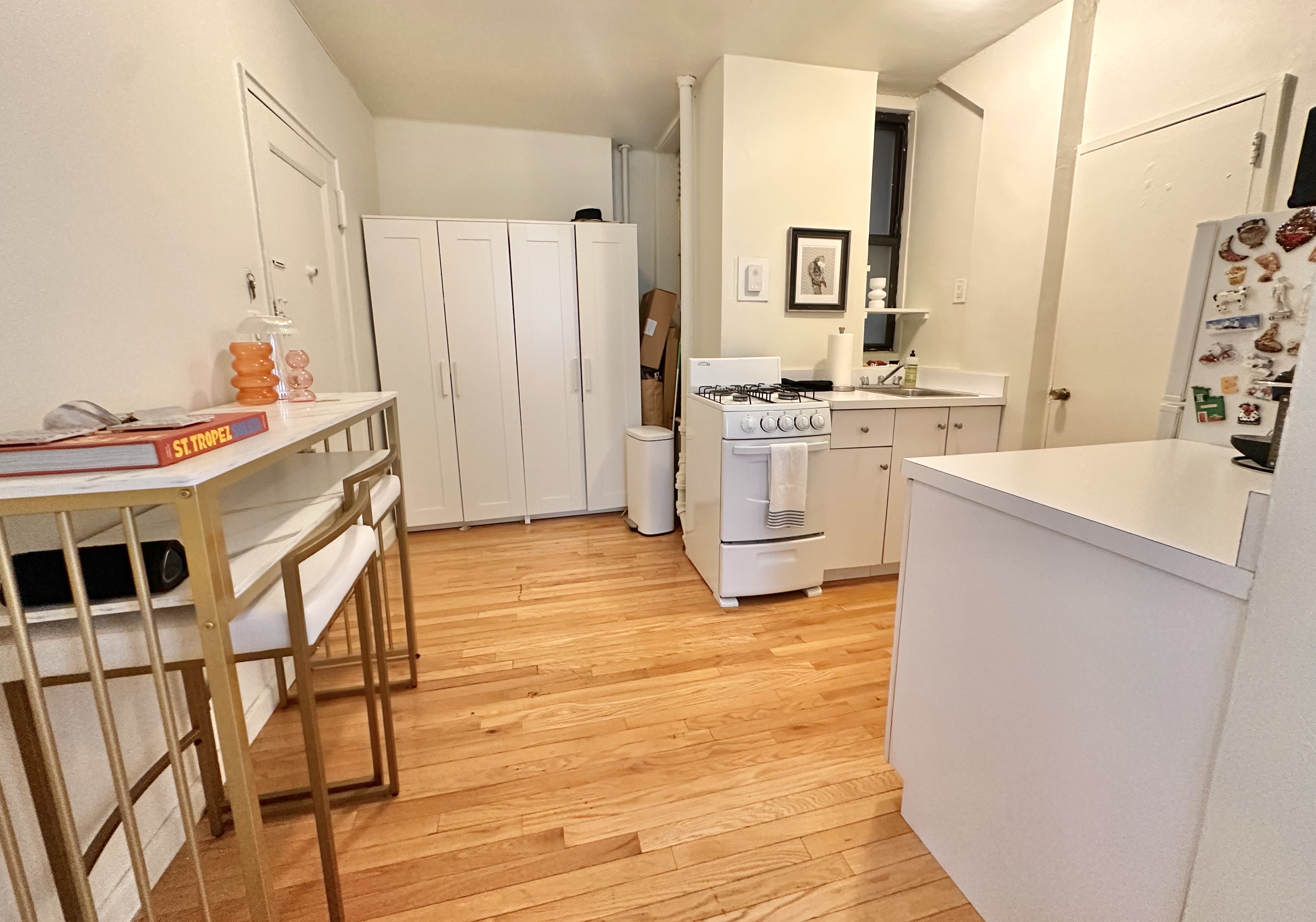 110 Thompson Street, Unit 1A Manhattan, NY 10012 - Photo 3 of 4 a kitchen with a sink cabinets and wooden floor