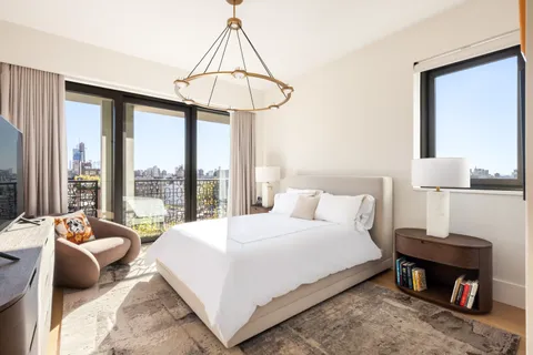 a bedroom with a bed and a chandelier