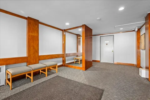 a view of an empty room with furniture and window