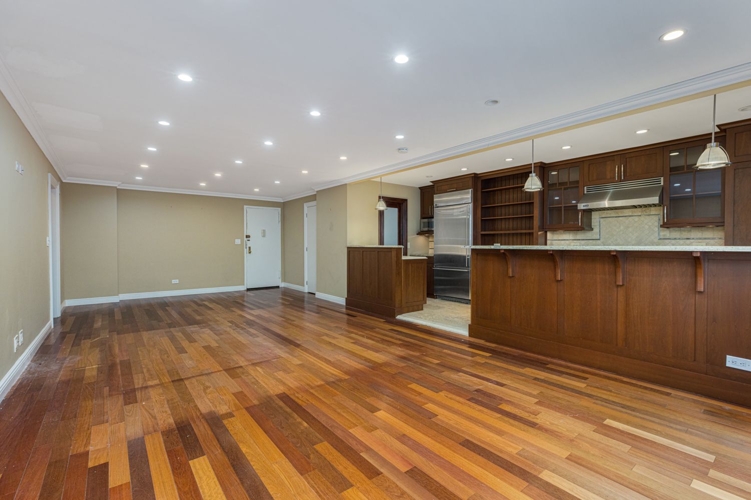 a view of kitchen with stainless steel appliances granite countertop refrigerator and stove top oven