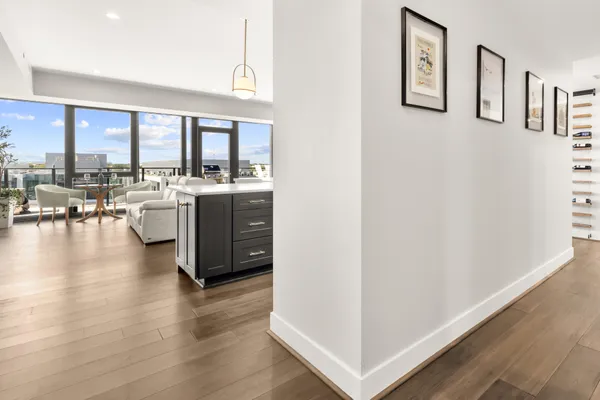 a view of a kitchen with kitchen island wooden floors and stainless steel appliances