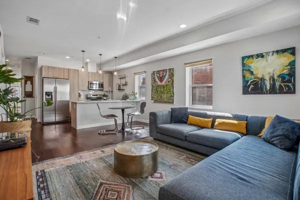 a living room with furniture and a view of kitchen
