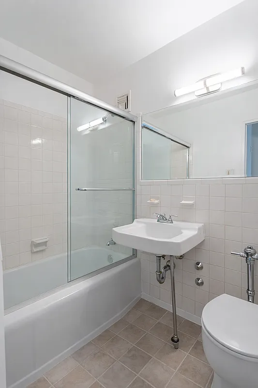 2575 Palisade Avenue, Unit 11J Bronx, NY 10463 - Photo 8 of 13 a bathroom with a sink toilet and shower