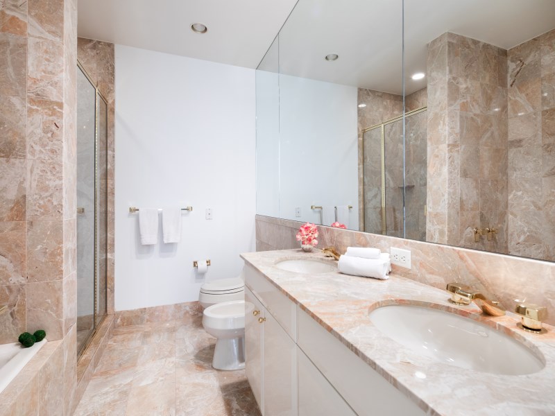 845 United Nations Plaza, Unit 33A Manhattan, NY 10017 - Photo 9 of 10 a bathroom with a granite countertop sink a toilet and a shower