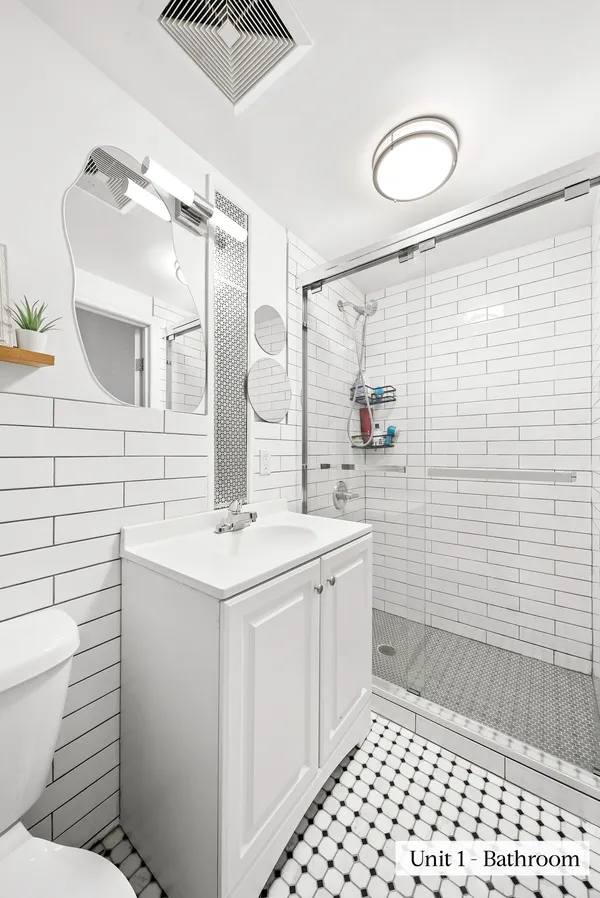 a bathroom with a sink a toilet and shower