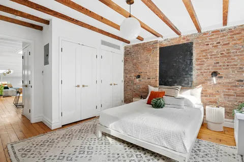 a bedroom with a bed and wooden floor