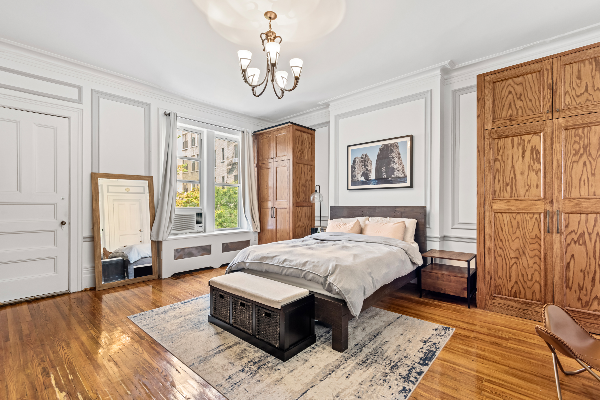311 West 78th Street Manhattan, NY 10024 - Photo 1 of 18 a bed sitting in a spacious bedroom next to a window