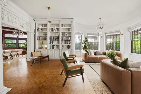 a living room with furniture and a chandelier