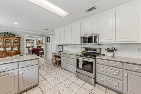 a kitchen with white cabinets stainless steel appliances and sink