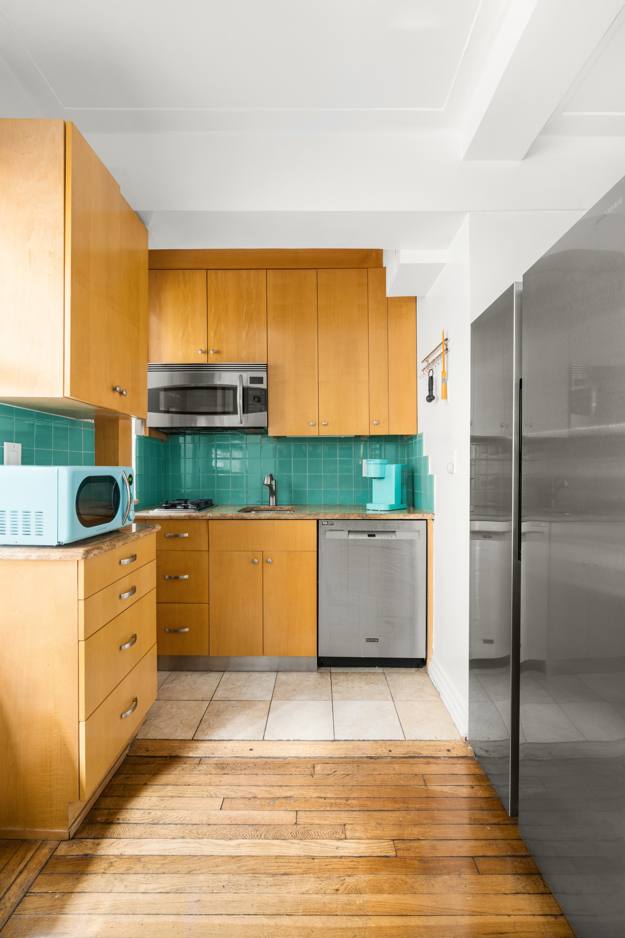 227 East 57th Street, Unit 3DEF Manhattan, NY 10022 - Photo 7 of 13 a kitchen with granite countertop a stove a sink and a refrigerator