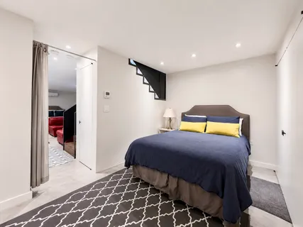 a bedroom with a bed and painting on the wall