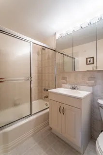 a bathroom with a sink and mirror with bathtub