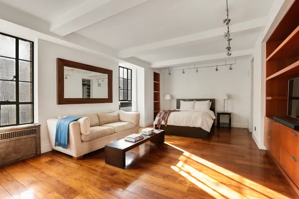 a spacious bedroom with a bed couch and a window