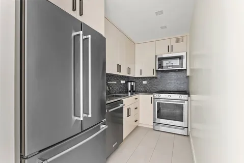a kitchen with stainless steel appliances granite countertop a refrigerator and a stove top oven