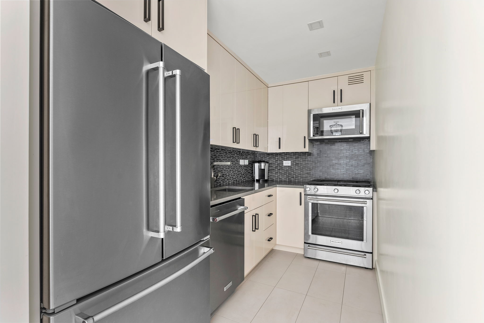 15 West 72nd Street, Unit 22O Manhattan, NY 10023 - Photo 5 of 8 a kitchen with stainless steel appliances granite countertop a refrigerator and a stove top oven