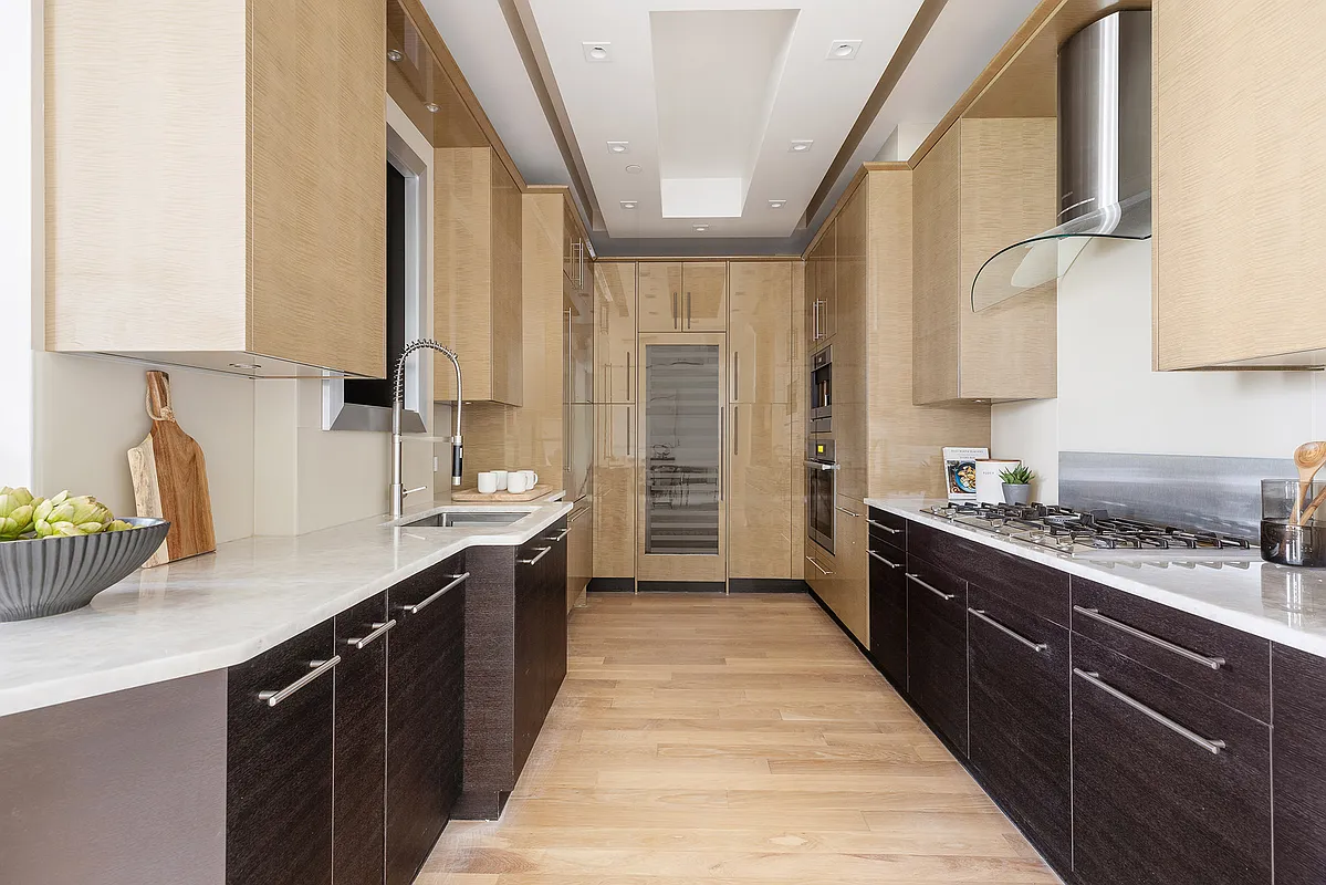 1 Central Park South, Unit 8010203 Manhattan, NY 10019 - Photo 39 of 45 a kitchen with stainless steel appliances a sink stove and cabinets