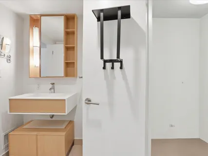 a bathroom with a sink and mirror with toilet