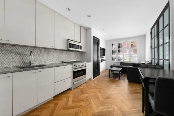 a kitchen with stainless steel appliances granite countertop a stove a sink and a microwave