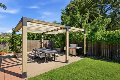 a view of a patio with table and chairs potted plants with wooden floor and fence