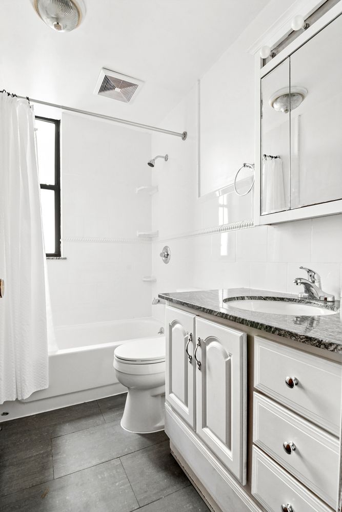 133 17th Street, Unit 4R Brooklyn, NY 11215 - Photo 6 of 7 a bathroom with a granite countertop sink a toilet and a shower