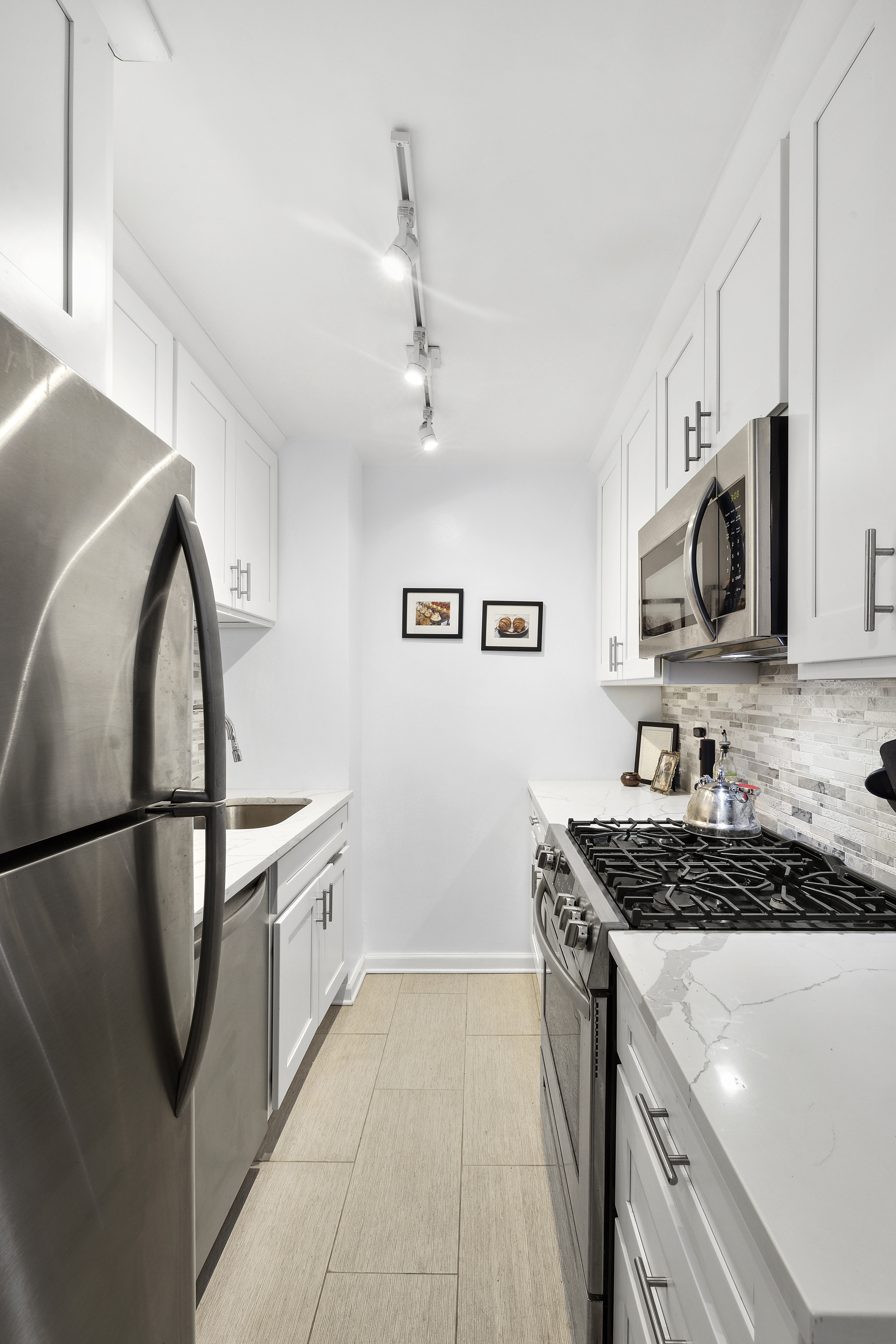 301 East 22nd Street, Unit 6L Manhattan, NY 10010 - Photo 5 of 7 a kitchen with stainless steel appliances granite countertop a stove a sink and a refrigerator